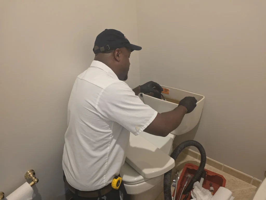 plumber fixing toilet flush tank